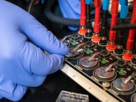 cell batteries with hand in purple glove