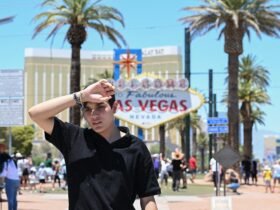 Person reacting to heatwave in front of Las Vegas sign