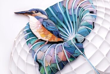 a quilled paper sculpture of a kingfisher in a leaf