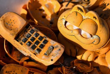 Spare parts of plastic 'Garfield' phones are displayed on the beach on March 28, 2019 in Plouarzel, western France, after being collected from a sea cave by environmental activists.