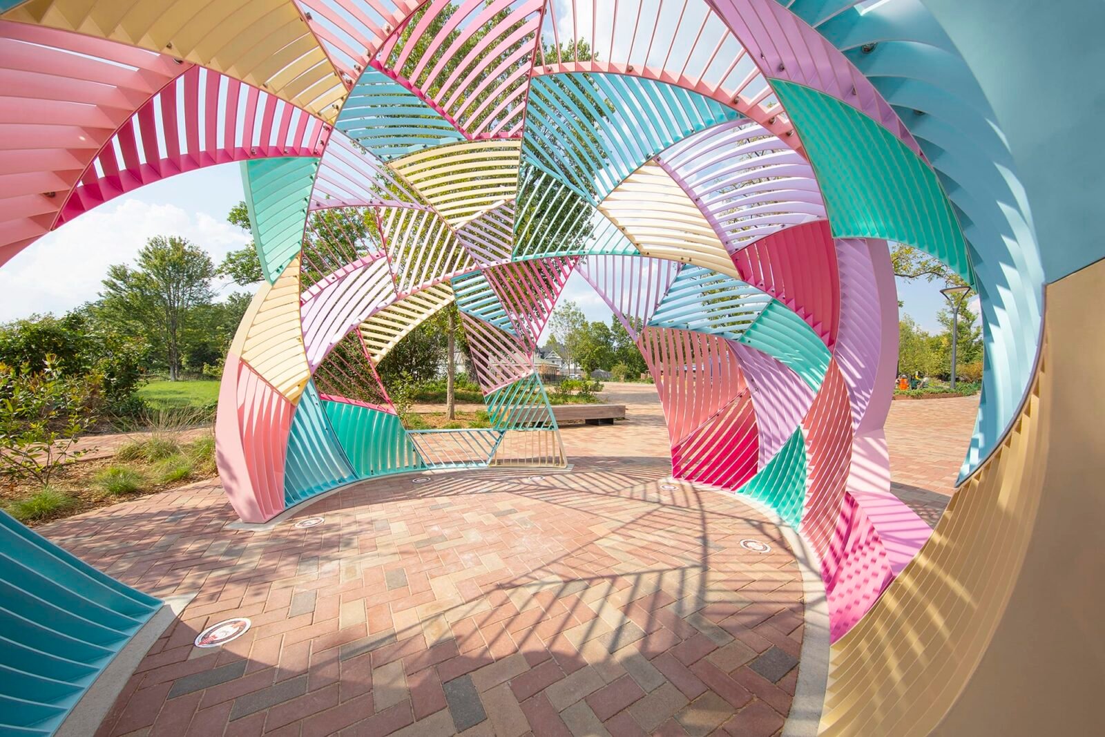 the interior of a colorful metal outdoor installation shaped like a dome with geometric facets