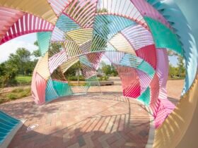 the interior of a colorful metal outdoor installation shaped like a dome with geometric facets