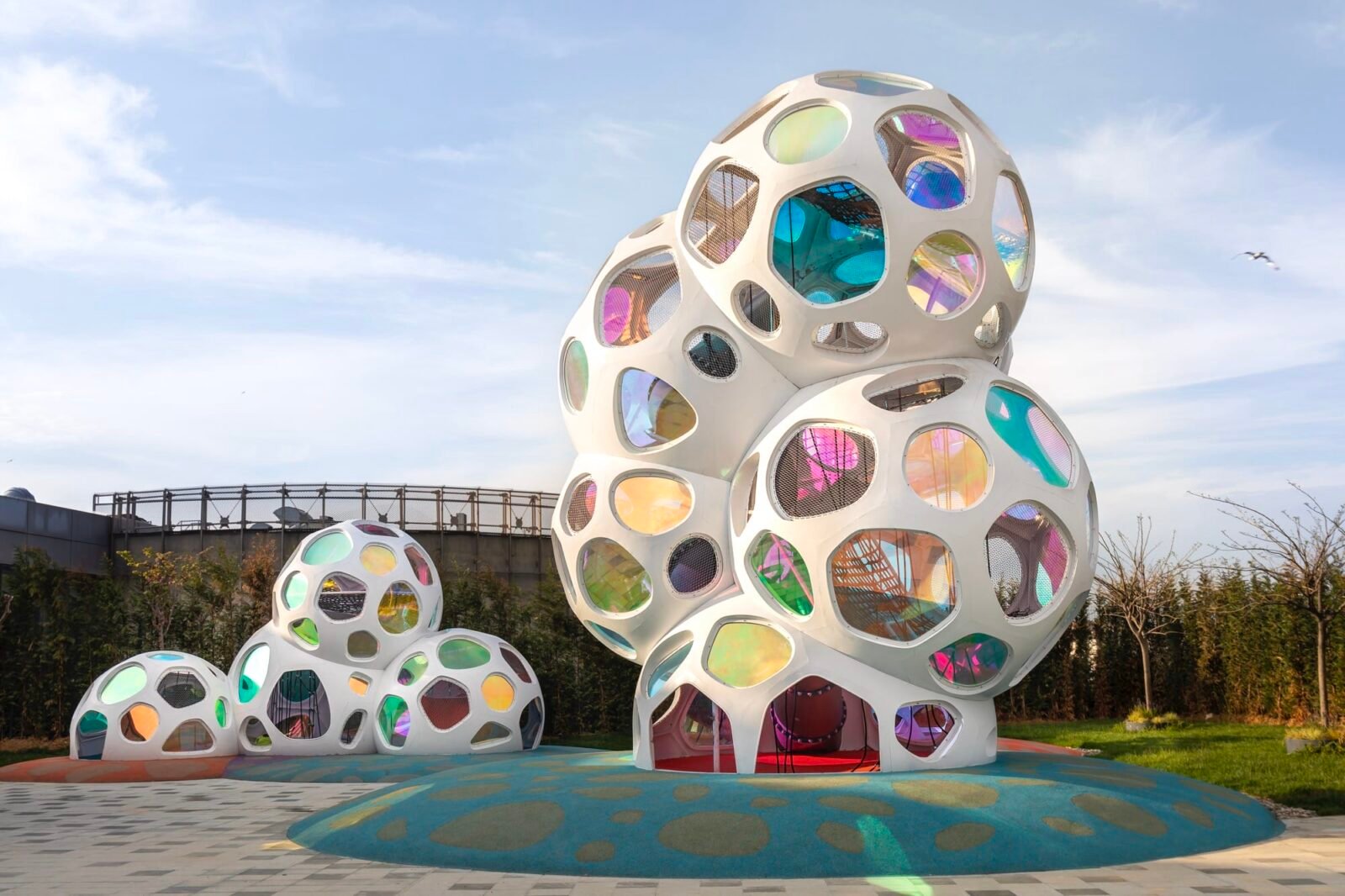 colorful hexagon windows fit into white bubbly structures on a playground