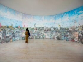 a woman stands in front of a round installation with various imagery