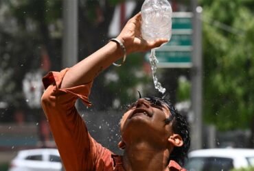 A boy in India pours water over his head.