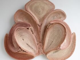 a symmetric pink coiled wall sculpture