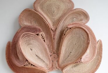 a symmetric pink coiled wall sculpture