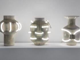 three ceramic vessels with shiny enamel coating that is intersected with curves of white neon lights