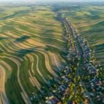 an aerial view of very long, narrow, undulating fields in rural Poland