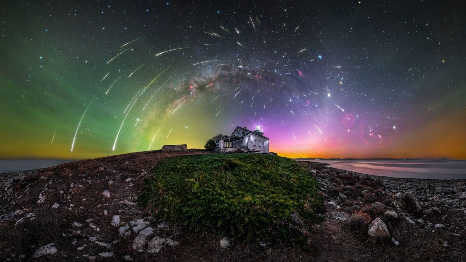 a glowing photograph of bright auroras, stars, and meteors over a mountain Croatian landscape with a house in the center