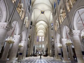 An image inside the Notre Dame cathedral shows a high vaulted ceiling and arches.