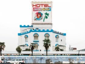 a bright white and blue facade of a castle-themed love hotel in Japan along the roadside