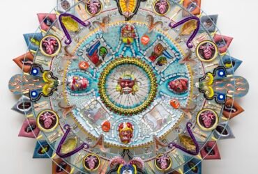 an abstract glass sculpture in the form of an Aztec calendar with numerous mixed-media details and patterns