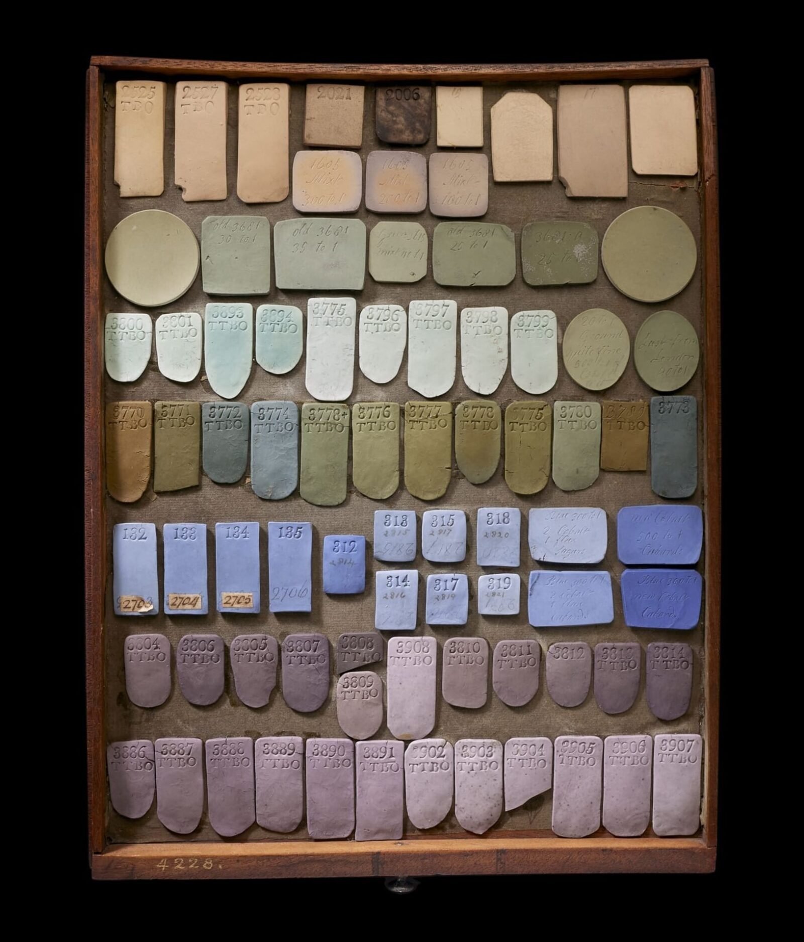 a tray of various shapes of ceramic pieces glazed with different colors