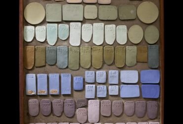 a tray of various shapes of ceramic pieces glazed with different colors