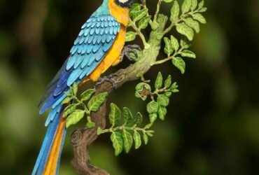 paper cutout artworks of a macaw sitting on a branch, held by the artist's hand to show tiny detail