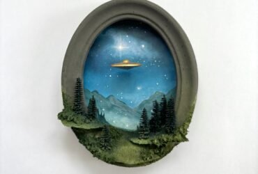 within a miniature ovoid frame, a detailed diorama depicts a landscape with a hovering UFO