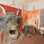 the interior of Ron Gittins' apartment in Birkenhead, England, featuring a very ornate, hand-sculpted fireplace of a bull's head with murals all around on the walls