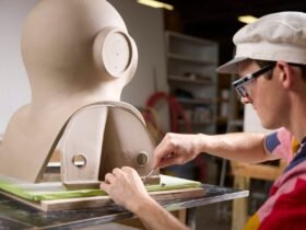 an artist works on a large almost figurative sculpture on a table