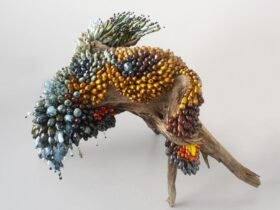 a botanical sculpture of bird, made from glass, wood, and ceramics