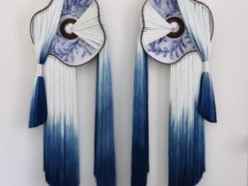 a wall installation made using blue-and-white fiber and blue-and-white glazed ceramic plates with the fiber connecting through holes in the plates and draping elegantly