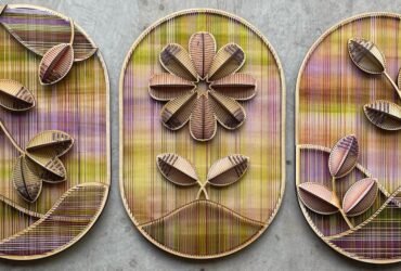 a trio of vibrant embroidered sculptural flowers on wood oval panels