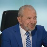 Lord Sugar smiling in the boardroom