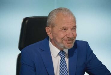 Lord Sugar smiling in the boardroom