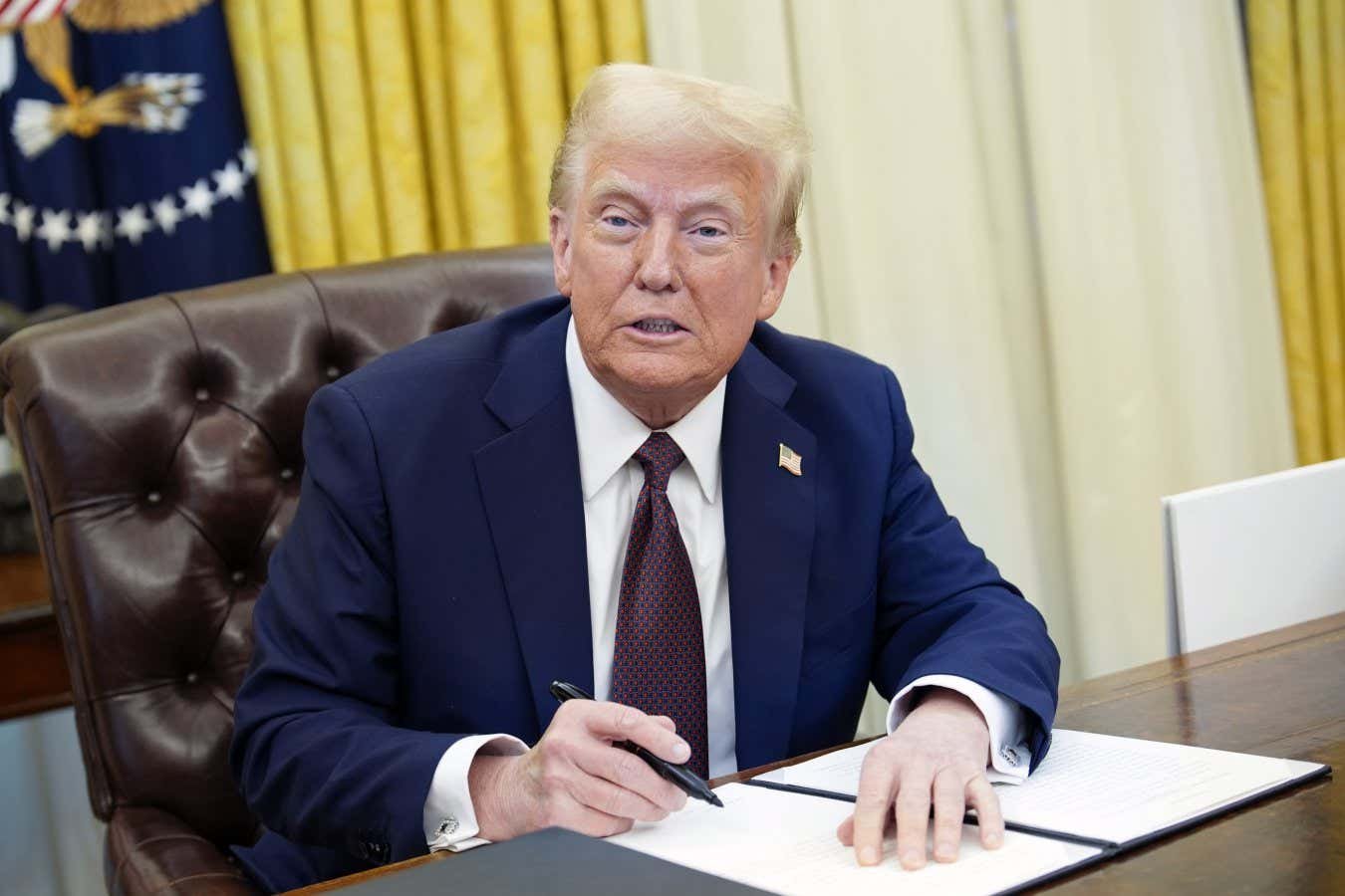 Trump signs executive orders in the Oval Office of the White House in Washington, DC, USA, 23 January 2025.