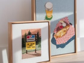 two framed embroideries with images of fried fish and a beer along with a grocery store sign and a marquee reading "ice cream cons pizza slice"