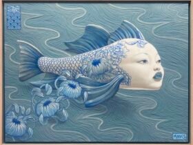 a combination woodcut and acrylic painting of a blue fish with the face of a human woman, with blue flowers falling from its back as it floats atop the surface of the water