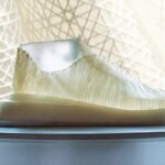 A shoe made of nanocellulose sits in front of a curtain.