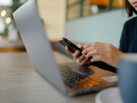 Woman working on laptop and phone