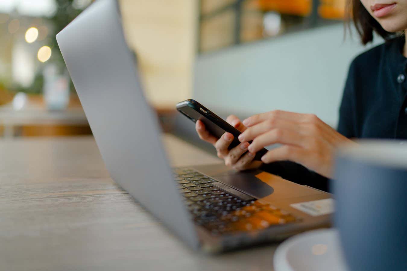 Woman working on laptop and phone