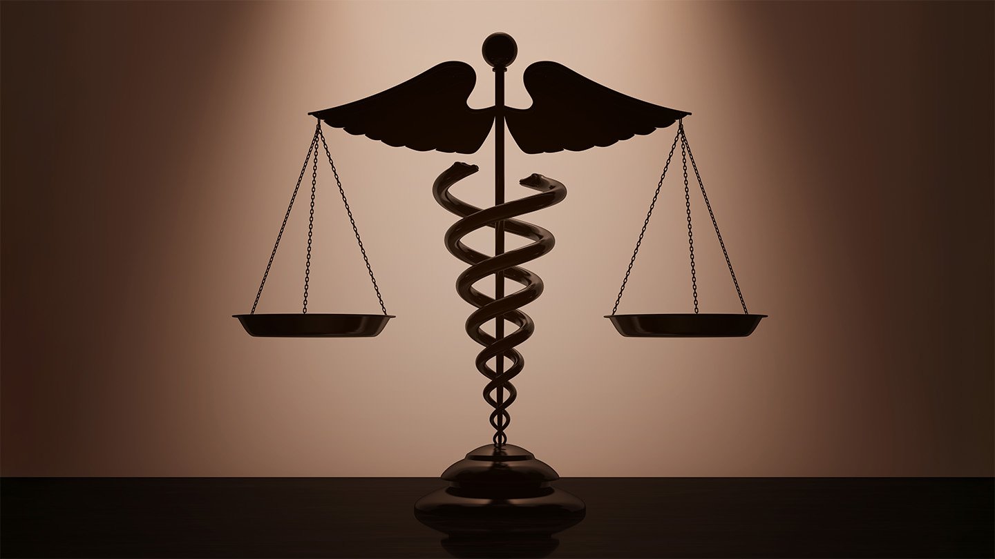 A medical caduceus with scales, silhouetted against a dimly lit, tan background