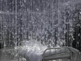 white glimmering tendrils dangle around a small twin bed