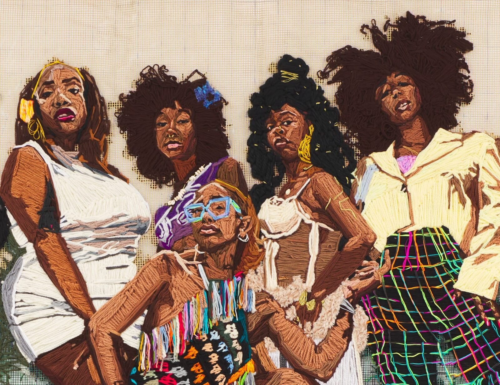 a detail of a large-scale embroidered group portrait of vibrantly-dressed Black women in a natural landscape