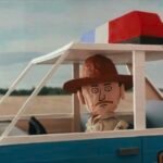 a still from a stop-motion animated video of a sheriff in his car