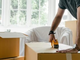 person taping a moving box