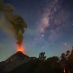 a volcano erupts beneath the milky way