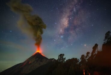 a volcano erupts beneath the milky way