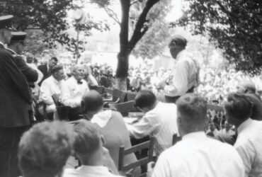 Two people having a discussion among a crowd of people watching.