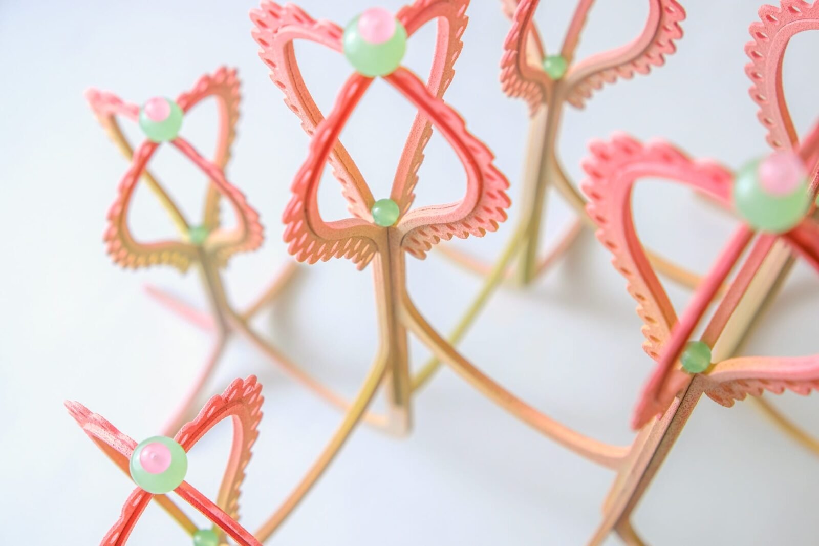 detail of a pink and yellow curved sculpture with scalloped edges