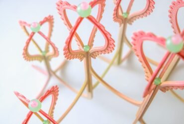 detail of a pink and yellow curved sculpture with scalloped edges