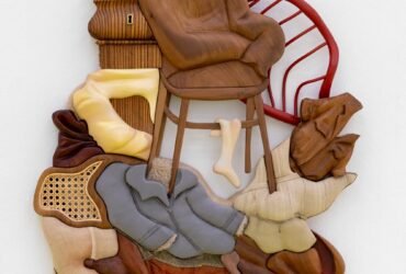 a mixed-media abstract wall sculpture with furniture and clothing forms