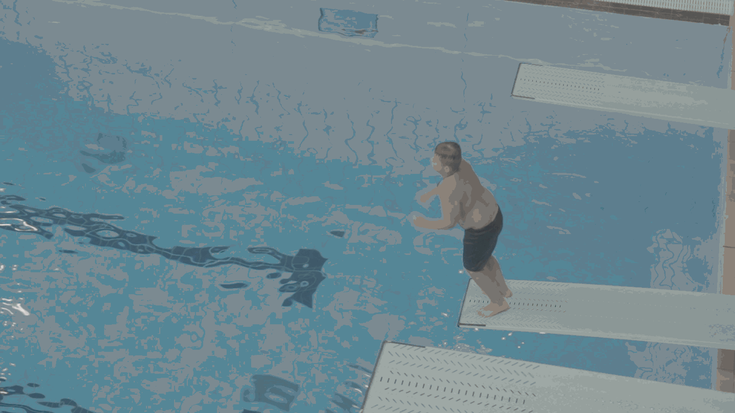 a gif of a man jumping into water in a v shape and making a big splash