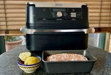 Ninja air fryer with a loaf cake in a tine in front of it