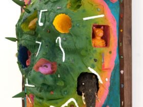 a side view of a wooly mammoth, pink animal, bell, and other objects embedded into a sculptural painting shaped like a face