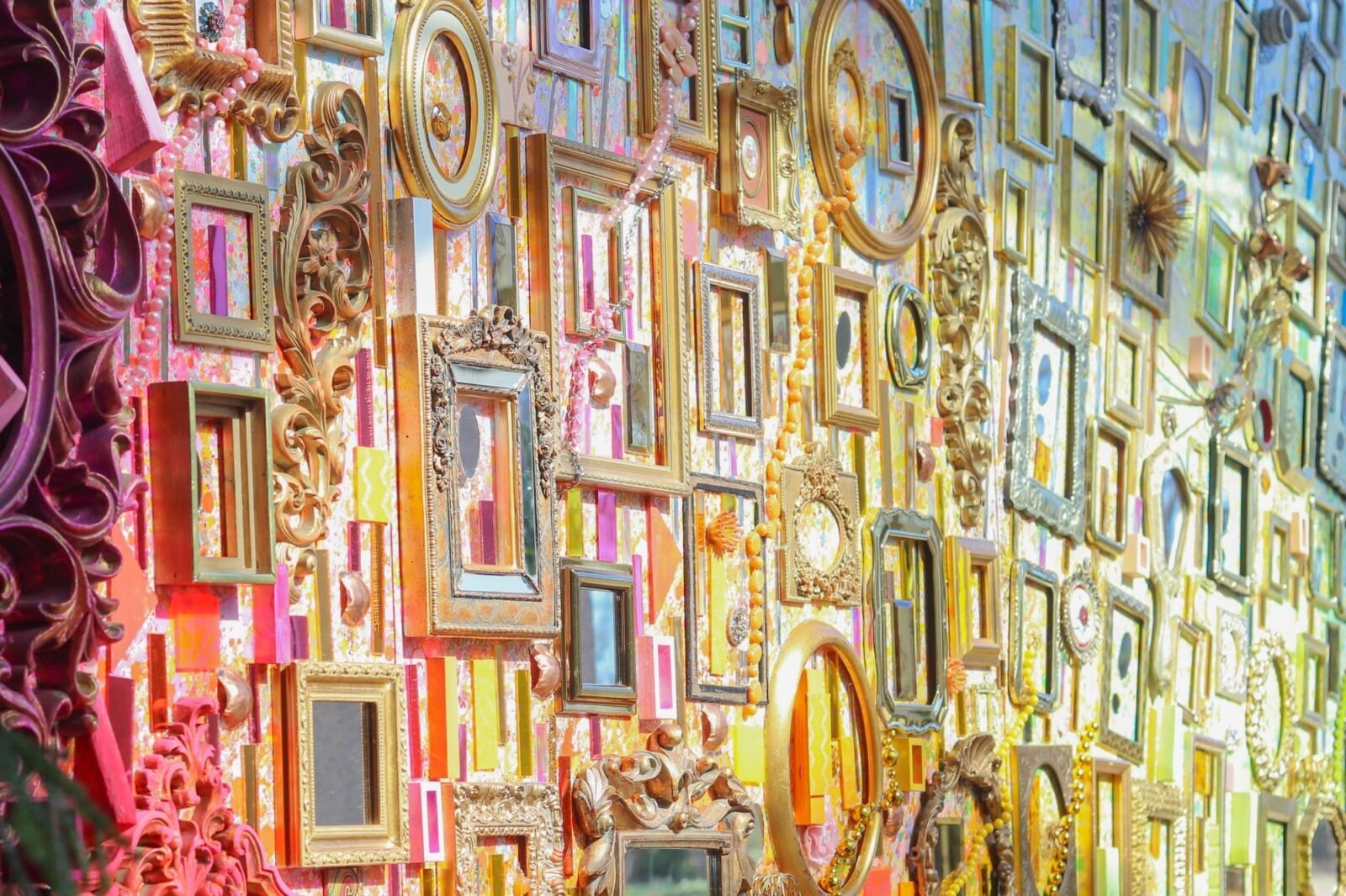 a detail of an assemblage made from tapestry elements and dozens of picture frames
