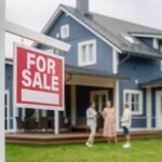 A couple talking to their realtor behind a "for sale" sign after the home inspection